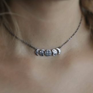 The Silver Plated Moon Phases Necklace displayed on someone's neck.