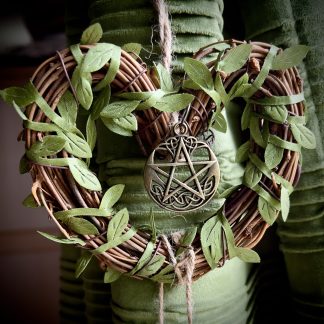 Close up of the protection witch bells heart wreath with a bronze pentacle.